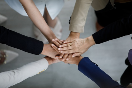 Group of hands in the middle to show teamwork and collaboration